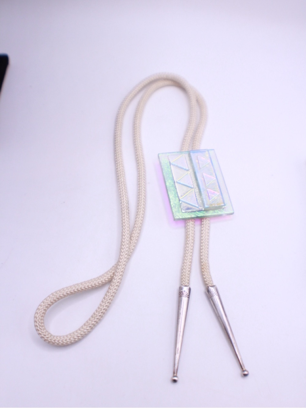 Iridescent dichroic glass bolo tie
 with Cream Cord engraved tips